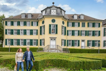 LVR-Industriemuseum - Textilfabrik Cromford Außenansicht Das Bild zeigt zwei Besucher*innen vor der monumentalen Fassade des LVR-Industriemuseums Textilfabrik Cromford in Ratingen.