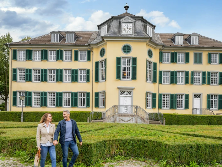 LVR-Industriemuseum - Textilfabrik Cromford Außenansicht Das Bild zeigt zwei Besucher*innen vor der monumentalen Fassade des LVR-Industriemuseums Textilfabrik Cromford in Ratingen.