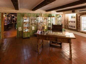 Duftmuseum Farina Das Bild zeigt ein historisches Museum mit antiker Inneneinrichtung, grünen Fliesen und Glasschränken.The picture shows a historical museum with antique interior design, green tiles and glass cabinets.