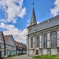 Historischer Ortskern mit Kirchplatz in Wülfrath Kirchplatz in Wülfrath mit beeindruckender Kirche und traditionellen Fachwerkhäusern unter blauem Himmel.