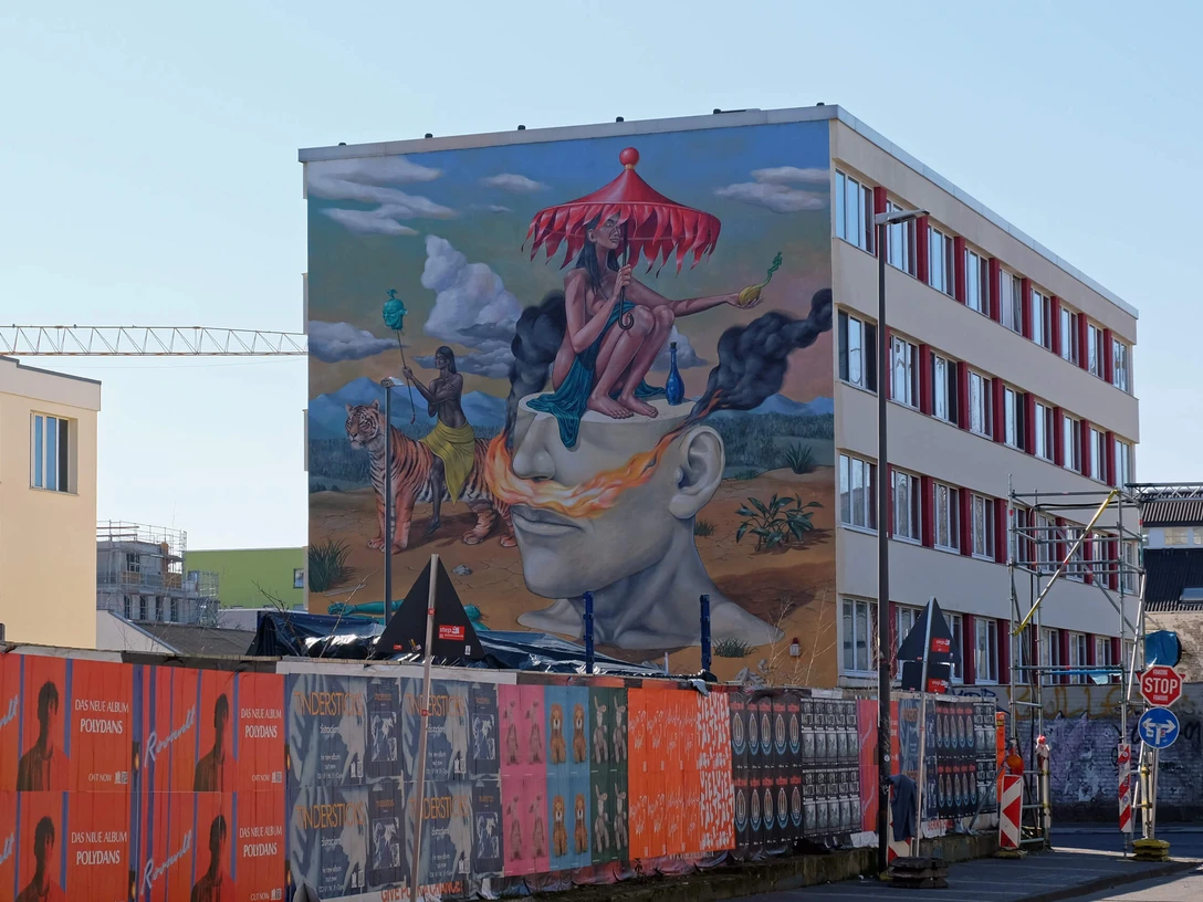 Mural Auf dem Bild ist eine farbenfrohe Wandmalerei zu sehen, die ein surrealistisches Motiv mit Figuren, Tieren und Landschaften darstellt.The picture shows a colorful mural depicting a surrealistic motif with figures, animals and landscapes.