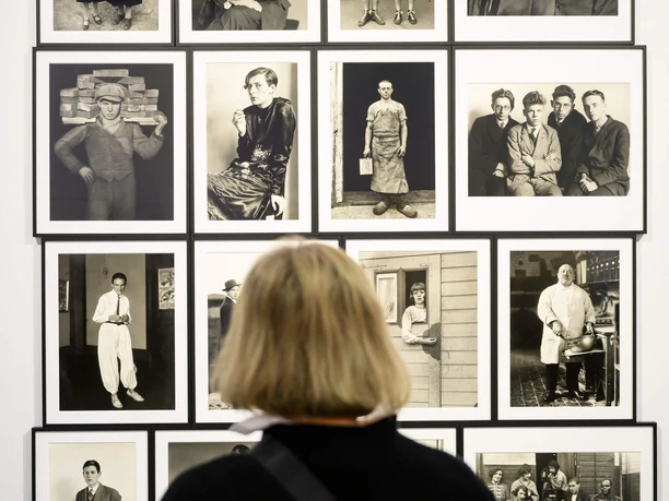 ART COLOGNE A person looks at the exhibits in front of a wall with eleven black and white photographs.