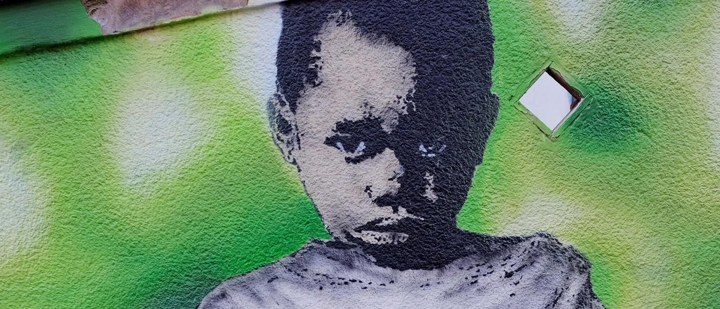 Mural A large-format graffiti shows a young boy with a serious look in front of a green background. The faded message on his sweater reads: "I WILL NEVER SAY WHAT YOU WANT TO HEAR".