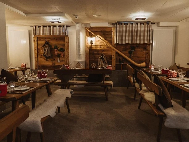 Rustikaler Gastraum im Restaurant Lok 7 mit gedeckten Holztischen und Alpen-Dekor