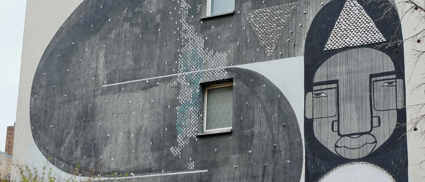 Mural The impressive mural on the building shows abstract shapes and faces in black and white tones.