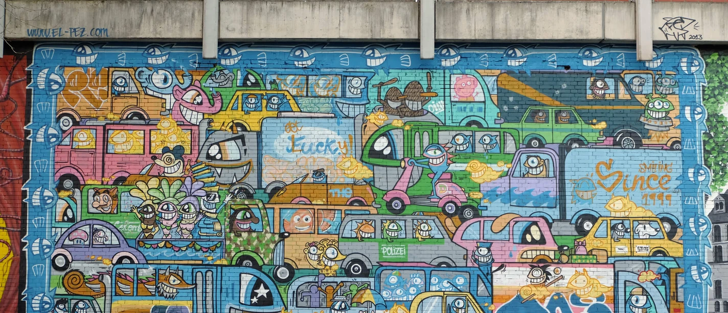 Mural Colorful mural with lots of cheerfully drawn cars, including parked bicycles.