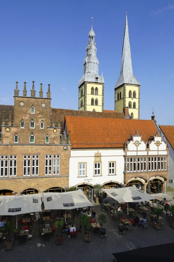 Marktplatz Lemgo Marktplatz Lemgo mit Fachwerkhäusern, hohen Kirchtürmen und belebten Café-Tischen bei Sonnenschein.