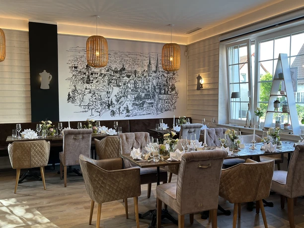 Ein stilvoller Speiseraum mit eleganten gepolsterten Stühlen, gedeckten Tischen und einer Wandillustration.