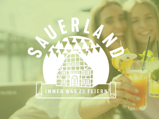 Zwei Personen stoßen mit bunten Cocktails an, während ein Sauerland‑Logo groß darüber liegt.