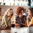 Studienkreis Vier Frauen sitzen an einem Tisch in einem Café und unterhalten sich bei Kaffee.