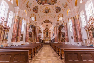 Führung durch die Frauenkirche in Günzburg Prächtige Innenansicht der Frauenkirche in Günzburg mit barocken Holzbänken und kunstvollen Fresken.