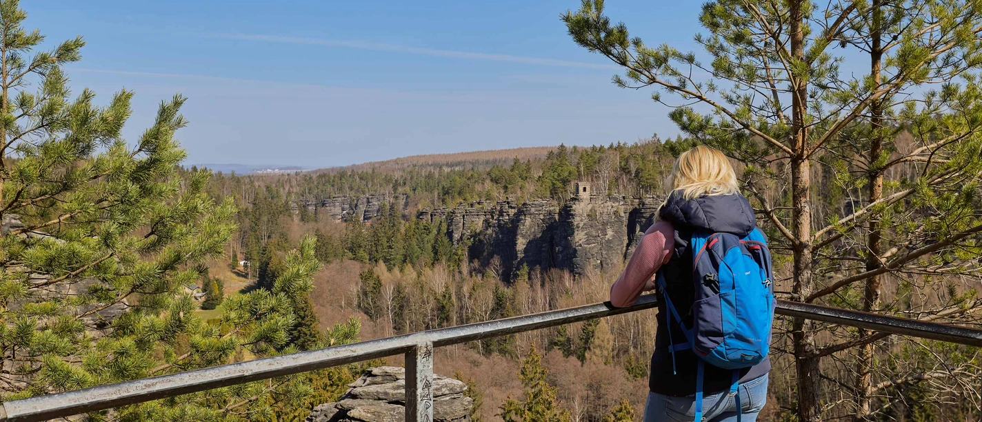 Johanniswacht im Bielatal Eine Frau betrachtet von einem Aussichtspunkt die beeindruckenden Felsen des Bielatals in Sachsen.