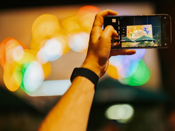 Rahmenprogramm Löffelfamilie auf der Feinkost für Ihre Tagung & Konferenz in Leipzig Rahmenprogramm Blick druch Handykamera auf die beleuchtete Reklame Löffelfamilie auf dem Gelände der Feinkost für Tagung & Konferenz Leipzig Convention