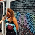 Mindwalk in Köln Zwei Menschen posieren vor einer farbenfrohen Wand mit bunten Flügeln, die sie spielerisch darstellen.Two people pose in front of a colorful wall with colorful wings, which they playfully depict.
