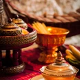 Traditionelle thailändische Speisen in kunstvoll verzierten Porzellanschalen auf einem gewebten Tuch.