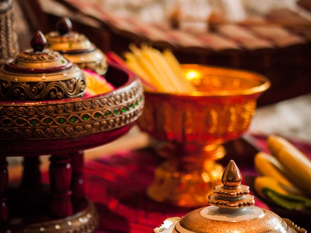 RoyalThai (8).jpg Traditionelle thailändische Speisen in kunstvoll verzierten Porzellanschalen auf einem gewebten Tuch.