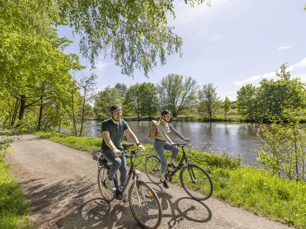 Radfahrer auf dem Aller-Radweg am Wasser