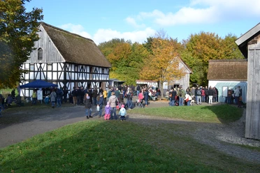Herbststimmung beim Kartoffelfest im LVR-Freilichtmuseum Lindlar Menschenmenge bei einem Herbstfest im Freilichtmuseum, umgeben von historischen Fachwerkhäusern.
