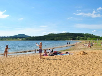 Vor der Kulisse der Landeskrone lässt es sich am Berzdorfer See am Strand entspannen