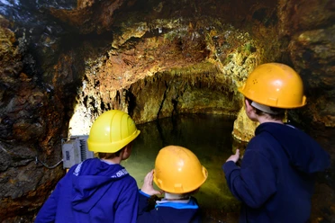 Familie bestaunt den unterirdischen See im Besucherbergwerk Mühlwand bei Reichenbach
