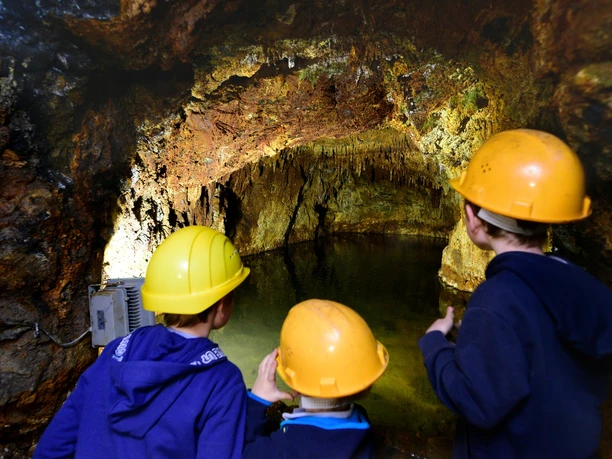 Familie bestaunt den unterirdischen See im Besucherbergwerk Mühlwand bei Reichenbach