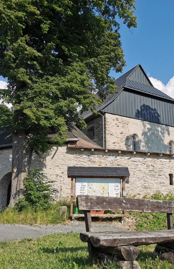 Wehrkirche Triebel mit Sitzgruppe und Informationstafel für Wanderer