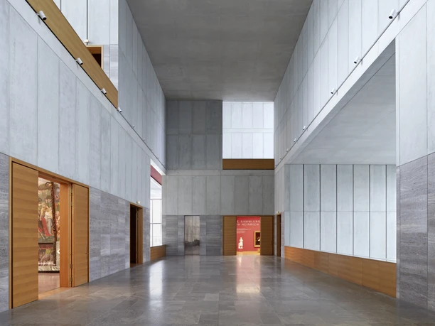 MdbK_1.OG_Halle_Foto_Punctum_A.Schmidt.jpg Großer, heller Raum mit hohen Decken, grauen Wänden und Holzelementen im Museum.