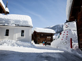 Dorfplatz im Bergdorf Münster mit Schneemann Johann dem 2.