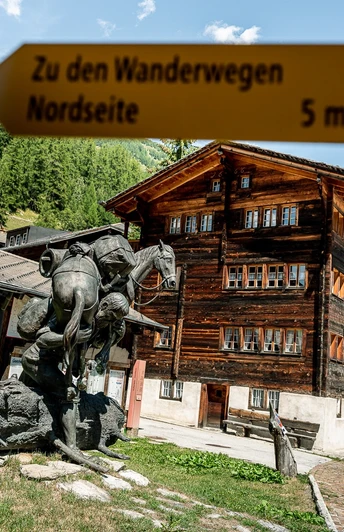 Unterwegs im Bergdorf Geschinen mit Baschi-Denkmal