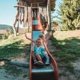 Zwei Kinder sitzen auf der Rutsche auf dem Spielplatz in Klosterreichenbach