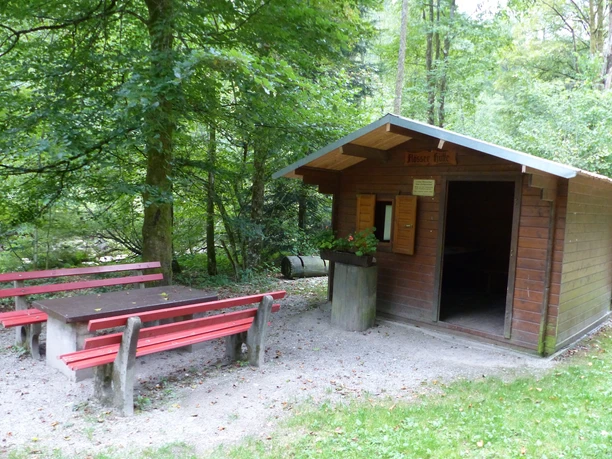 Eine Holzhütte schützt beim Grillen vor Sonne, Regen und Wind.