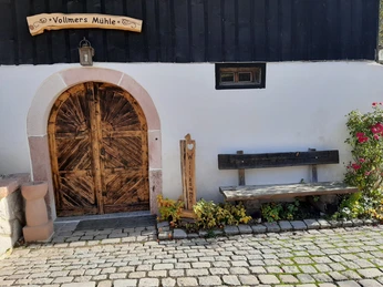 Eingang zur Vollmer´s Mühle mit Sitzbank und herzlich Willkommen