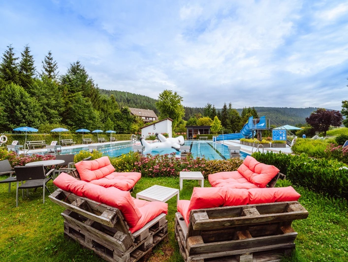 Übersicht über das Freibad mit Sitzecke, Rutsche und Spieltier