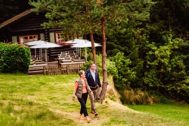 Ein Paar steht vor der Blockhütte in Tonbach