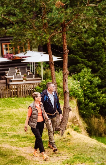 Ein Paar steht vor der Blockhütte in Tonbach
