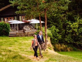 Ein Paar steht vor der Blockhütte in Tonbach