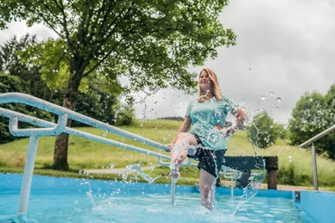 Eine Frau steht in einem Kneipp-Becken in Baiersbronn