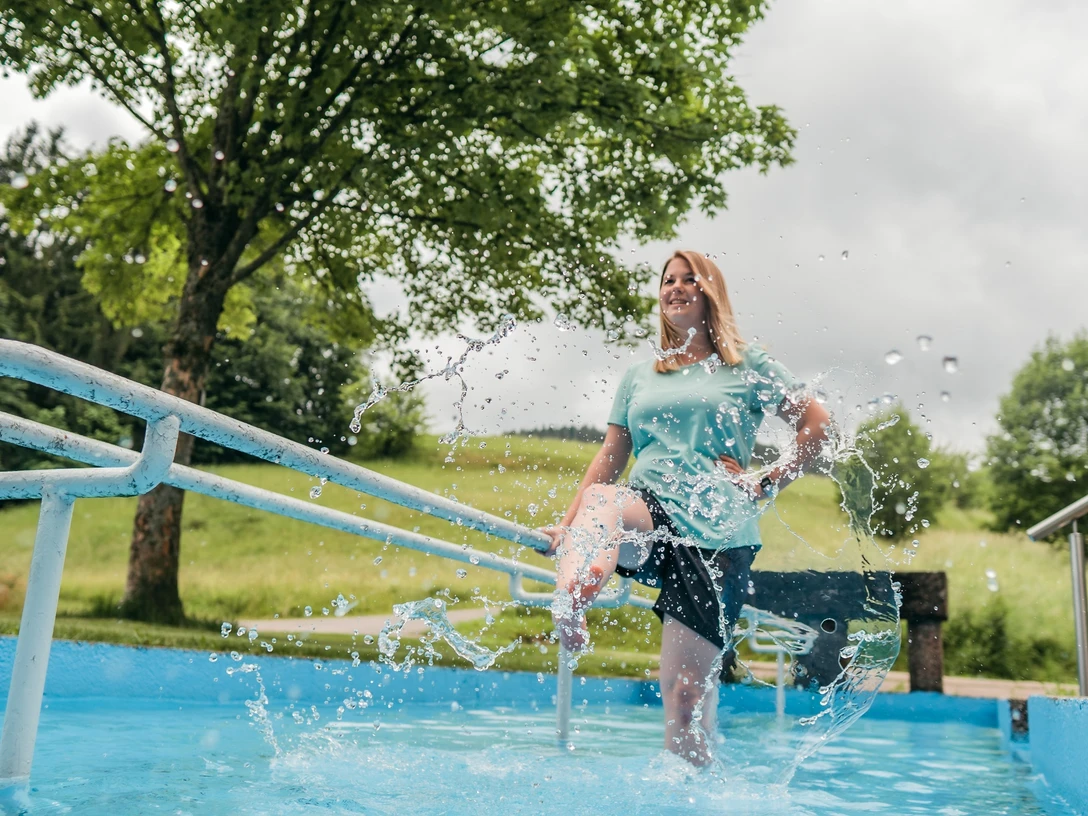 Eine Frau steht in einem Kneipp-Becken in Baiersbronn