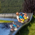 Mann und Junge auf der Sommerrodelbahn Mann und Junge auf der Sommerrodelbahn