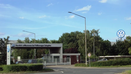 VolkswagenSalzgitter (3).JPG Eingangstor zum Volkswagen Werk Salzgitter mit großem VW-Logo an einem sonnigen Tag.