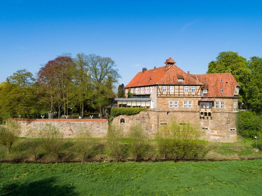 schloss_petershagen_weser_0797a.jpg Historisches Schloss Petershagen an der Weser, umgeben von Grünflächen und altem Baumbestand.
