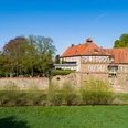 schloss_petershagen_weser_0797a.jpg Historisches Schloss Petershagen an der Weser, umgeben von Grünflächen und altem Baumbestand.