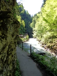Partnachklammeingang Schmaler Weg am Fels entlang über einem rauschenden Fluss zwischen hohen Waldhängen