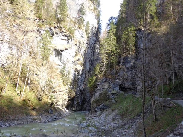 Hinterer Klammausgang Schmale Klamm mit steilen Felswänden, grünem Fluss und Waldhängen unter hellem Himmel