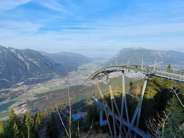 Blick ins Tal Weitblick über ein alpines Tal mit Bergen und einer hohen Aussichtsplattform im Vordergrund