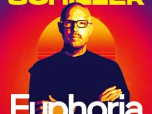 Das Bild zeigt einen Mann mit Brille und ernster Miene, vor einem stilisierten Sonnenuntergang.