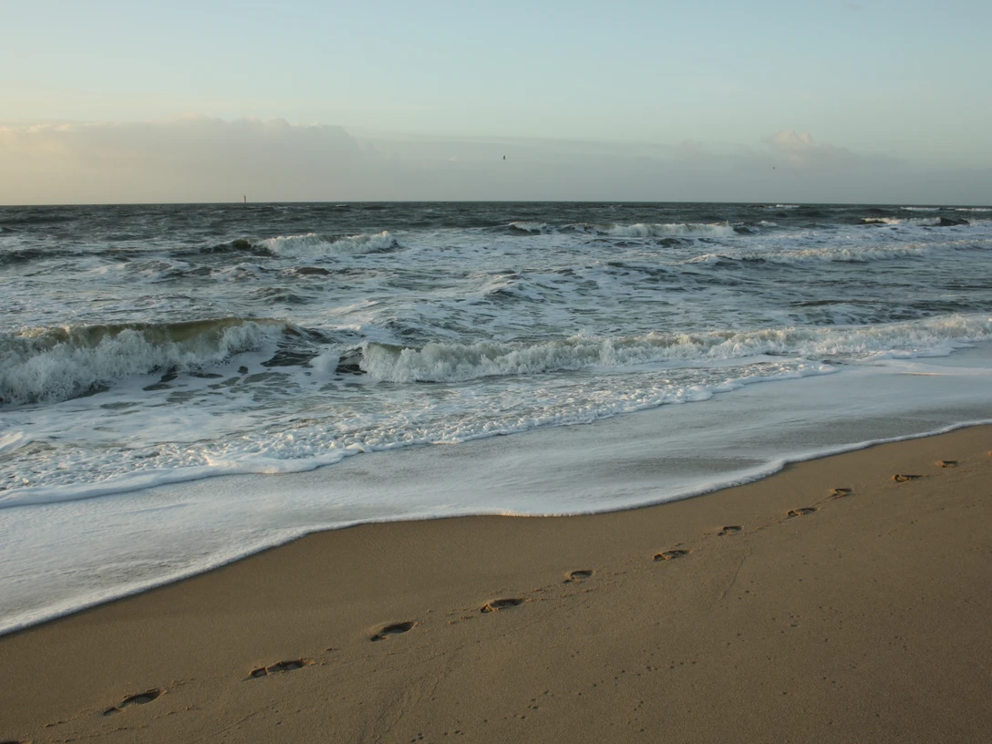 Fußspuren am Flutsaum im Winter.