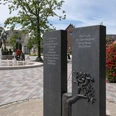 Denkmal jüdische Gemeinde 164 © Markus Stein.jpg Gedenktafel mit Baumrelief in gepflastertem Platz, Fontäne und umliegenden Gebäuden im Hintergrund.