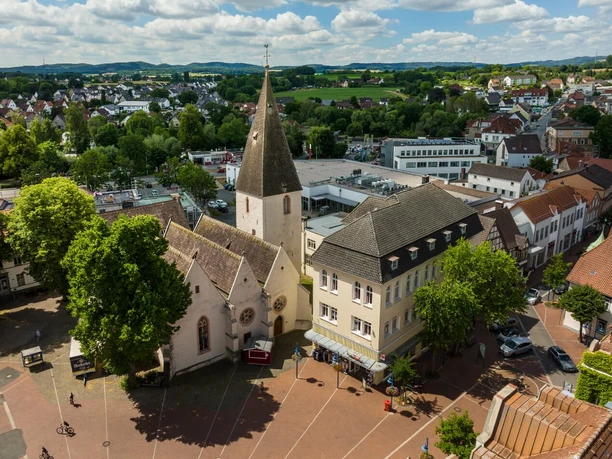 Marktkirche Marktkirche mit steilem Turm umgeben von lebendigem Marktplatz und grüner Landschaft unter blauem Himmel.