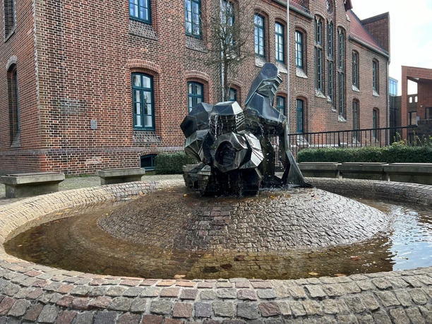 Set against a backdrop of brick buildings, the Dwarf Fountain stands out with its modern, sculptural forms.